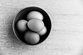 A ceramic bowl full of organic free-range eggs (black-and-white photo)