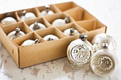 Vintage-style Christmas baubles in old cardboard box