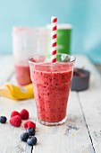 Grapefruit-Beeren-Smoothie mit Strohhalm im Glas