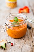 Red pepper hummus in a flip-top glass jar (vegan)