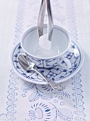 Ostfriesentee zubereiten: Kandiszucker in die Teetasse geben