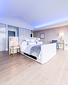 Glamouröses Schlafzimmer unter dem Dach mit blauen Licht