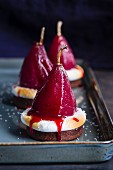 Desserts with red wine infused pears and meringues