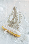 An eclair and a silver Eiffel Tower model for Christmas