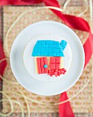 A cupcake decorated with a fondant cottage