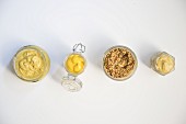 Vier Senfsorten (Körniger Senf, gelber Senf, Dijon-Senf und Brauner Senf) in einer Reihe