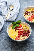 A smoothie bowl with mango, passion fruit, strawberries and pomegranate