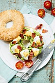 A bagel with bacon, avocado and egg