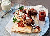 Meatballs on thin flatbread with a garlic dip and a hot pepper dip