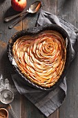 A heart-shaped apple tart with a dusting of icing sugar and cinnamon