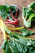 Three different kinds of chard on a wooden board