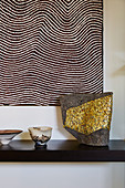 Sculpture with golden mosaic under a picture with wavy lines