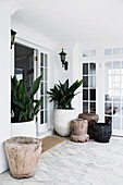 Large plant containers in the hallway with marble floors