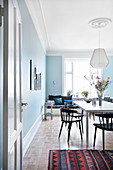 Dining room with pale blue walls in period apartment