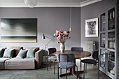 Sofa and dining table in interior in shades of grey