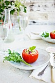 Tomaten gefüllt mit Quinoa-Tabouleh serviert mit Weißwein auf Tisch im Freien