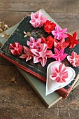 Origamiblumen in verschiedenen Rottönen auf alten Büchern