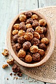 Energy balls with sunflower seeds, honey and cocoa in a wooden bowl