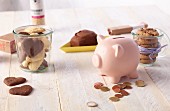Biscuits and a piggy bank with some coins on a wooden table