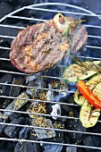 Steak and zucchini on a grill with herbs and spices