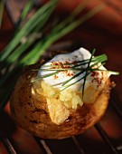 A baked potato with cream fraiche and chives