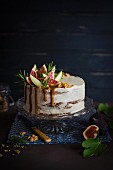 apple and fig cake with vanilla cream cheese icing and toffee sauce on a cake stand