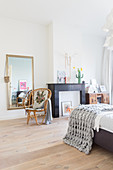 Black mantelpiece in bedroom with wooden floor