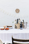 Tisch mit Zutaten für Vorspeise und Getränken vor weißer Wand auf der Terrasse