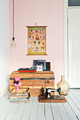Old trunk and flea-market finds on floor in front of pink wall