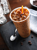 Iced Coffee in a Plastic Cup; Wrapped Straw