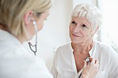 Female doctor examining senior woman