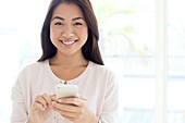 Woman using smartphone, smiling