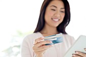 Woman holding credit card and tablet