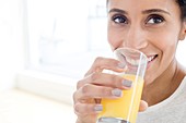 Woman drinking glass of orange juice