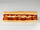 A meatball sub sandwich cheese and tomato sauce
