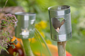 DIY-Windlichter aus Konservendosen auf Ast-Stäben im Garten