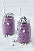 Two glasses of blueberry kefir with marshmallows