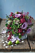 Colourful arrangement of purple roses, ornamental cabbage and pink pepper