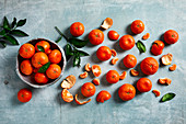 Various different sizes of mandarins, partially peeled