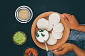 Idli (steamed rice cakes from India) with coriander and coconut chutney