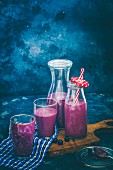 Blueberry and oat smoothie in bottles and glasses