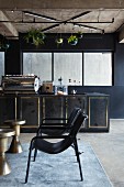 Black armchair and gilt side tables in front of bar