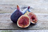 Fresh figs, whole and halved, on a wooden table