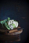 Cauliflower and a knife on a wooden table