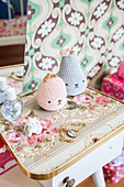 Necklace, crocheted fruit, bottle of perfume and cat ornament on table