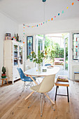 Dining table, chairs and bench in front of vintage bookcase next to terrace doors