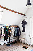 Clothes rail in attic room with wooden floorboards