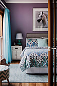 Pferdebild an lilafarbener Wand über dem Bett im Schlafzimmer