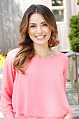 A young woman wearing a layered-look pink blouse