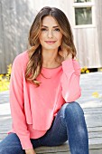 A young woman wearing a layered-look pink blouse